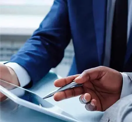 A man in a suit is holding a pen and tablet